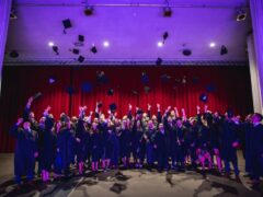 MBA Absolventen mit Talar schmeißen Hüte in die Luft.