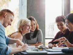 Gruppe Studiernde sitzt gemeinsam am Tisch