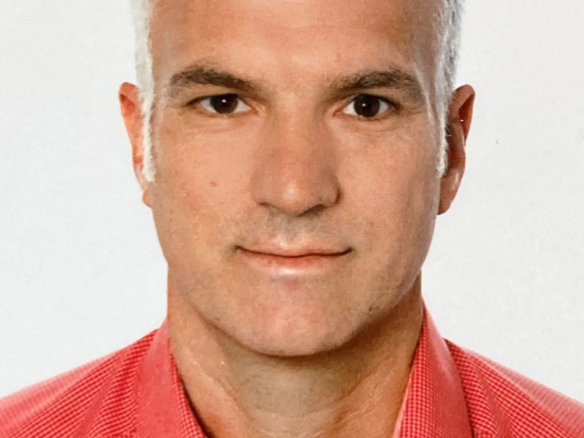 Portrait von Arndt Götzfried in einem roten Hemd.