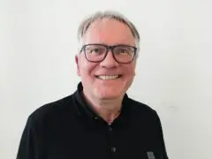 Portrait von Sebastian Schwarz mit Brille und schwarzem Hemd