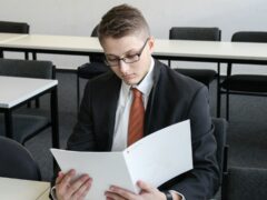 Wirtschaftspsychologie-Absolvent beim Durchsehen von Unterlagen header
