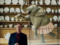 Prof. Dr. Dirk Jacob, Vizepräsident der Hochschule Kempten, steht vor einer Media-Wand auf der ein Ki-Generiertes Bild von einem Elefanten im Tutu vor einem Regal mit Geschirr aus Porzellan. Er hält einen Vortrag über den Elefanten im Porzellanladen, warum Ingenieure Psychologie brauchen