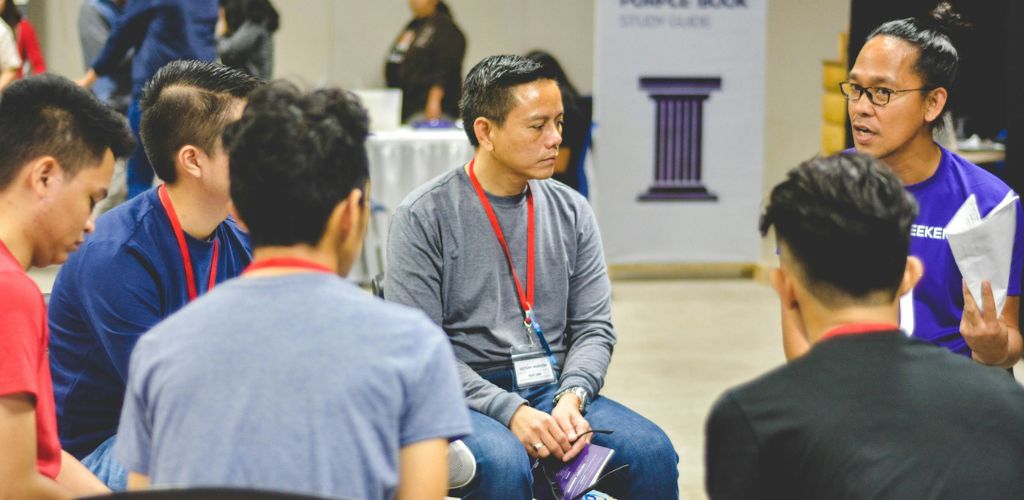 Teilnehmer eines Programms für Master Beratung, Organisationsentwicklung & Coaching sitzen im Kreis und tauschen sich im Rahmen einer Coaching-Session aus Master Coaching