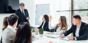 Eine Gruppe von Executive-MBA-Absolventen diskutiert in einem Konferenzraum über Karrieremöglichkeiten. Executive MBA