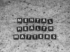 Schwarze Steine mit weißen Buchstaben auf einer Steinplatte, sie bilden die Worte "Mental Health Matters"