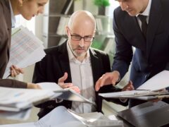 Wertschöpfung in der Krise: Führungskräfte analysieren Finanzunterlagen und treffen gemeinsam strategische Entscheidungen