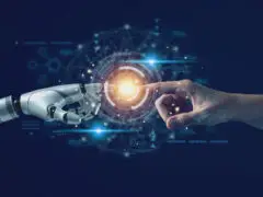 Was ist künstliche Intelligenz? Eine menschliche Hand und eine Roboter-Hand berühren sich an den Zeigefingern.